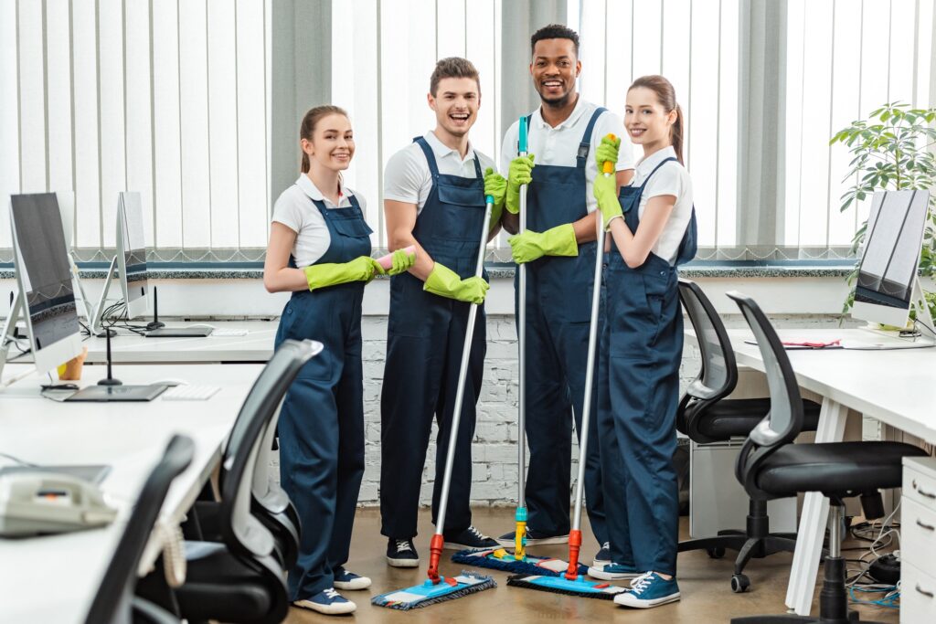 Office cleaning services team in Washington DC. Smiling cleaning crew with mops ready to clean office space, commercial cleaning services.