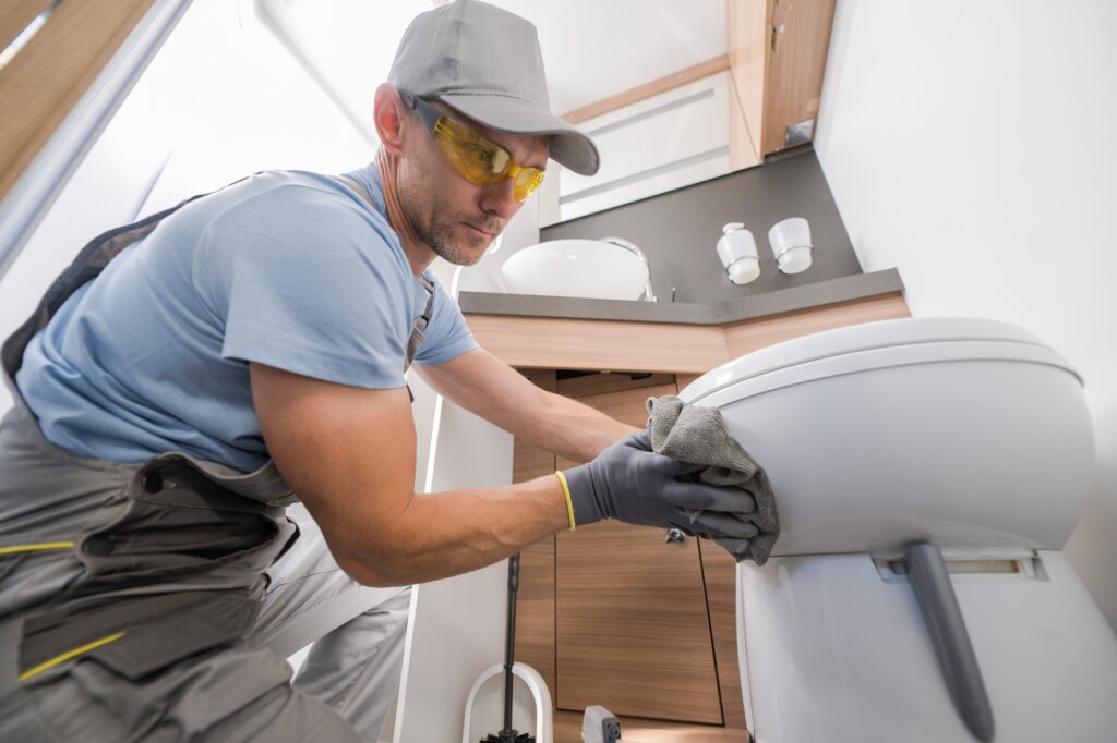 Janitor cleaning toilet bowl with cloth. Professional cleaning service for residential and commercial properties. Janitorial services in Washington DC.