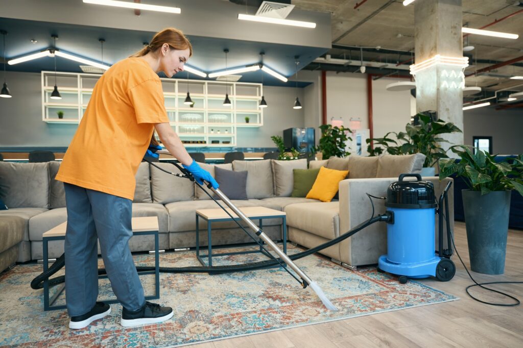 Carpet cleaning services: Woman using professional equipment to clean a carpet in an office. Rug cleaning service in Washington DC.