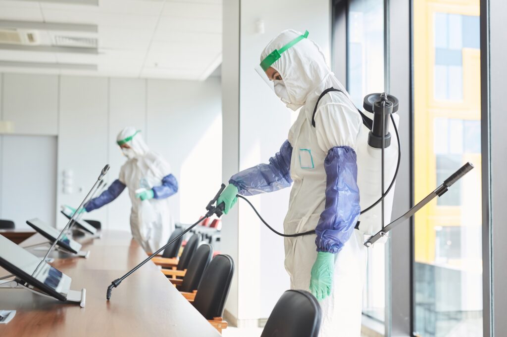 Commercial Disinfection Services: Staff in protective suits sanitizing a conference room in Washington DC. Professional disinfection for businesses.